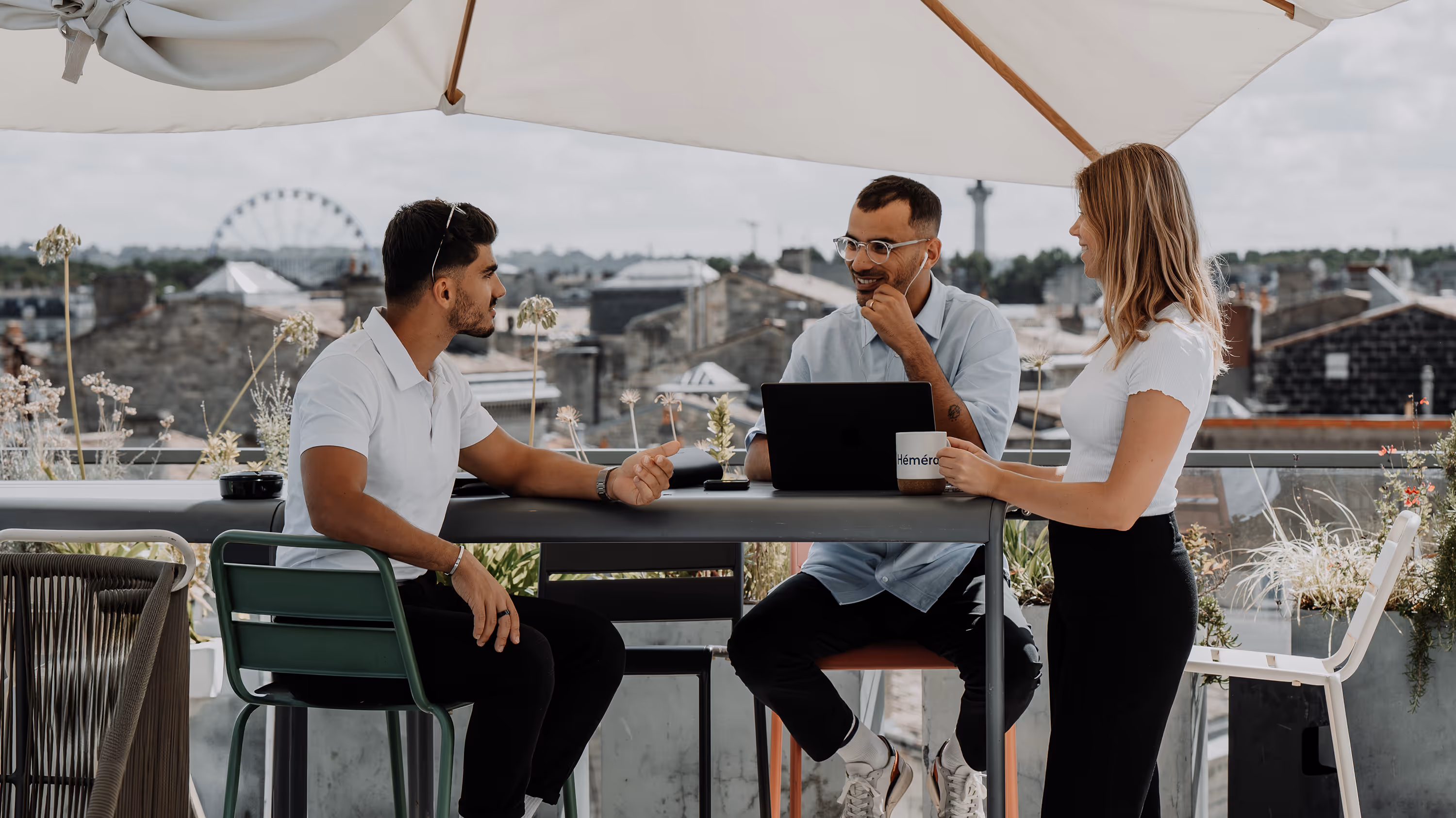 Photo de 3 Operating Partner travaillant en extérieur, avec une vue de Bordeaux en fond